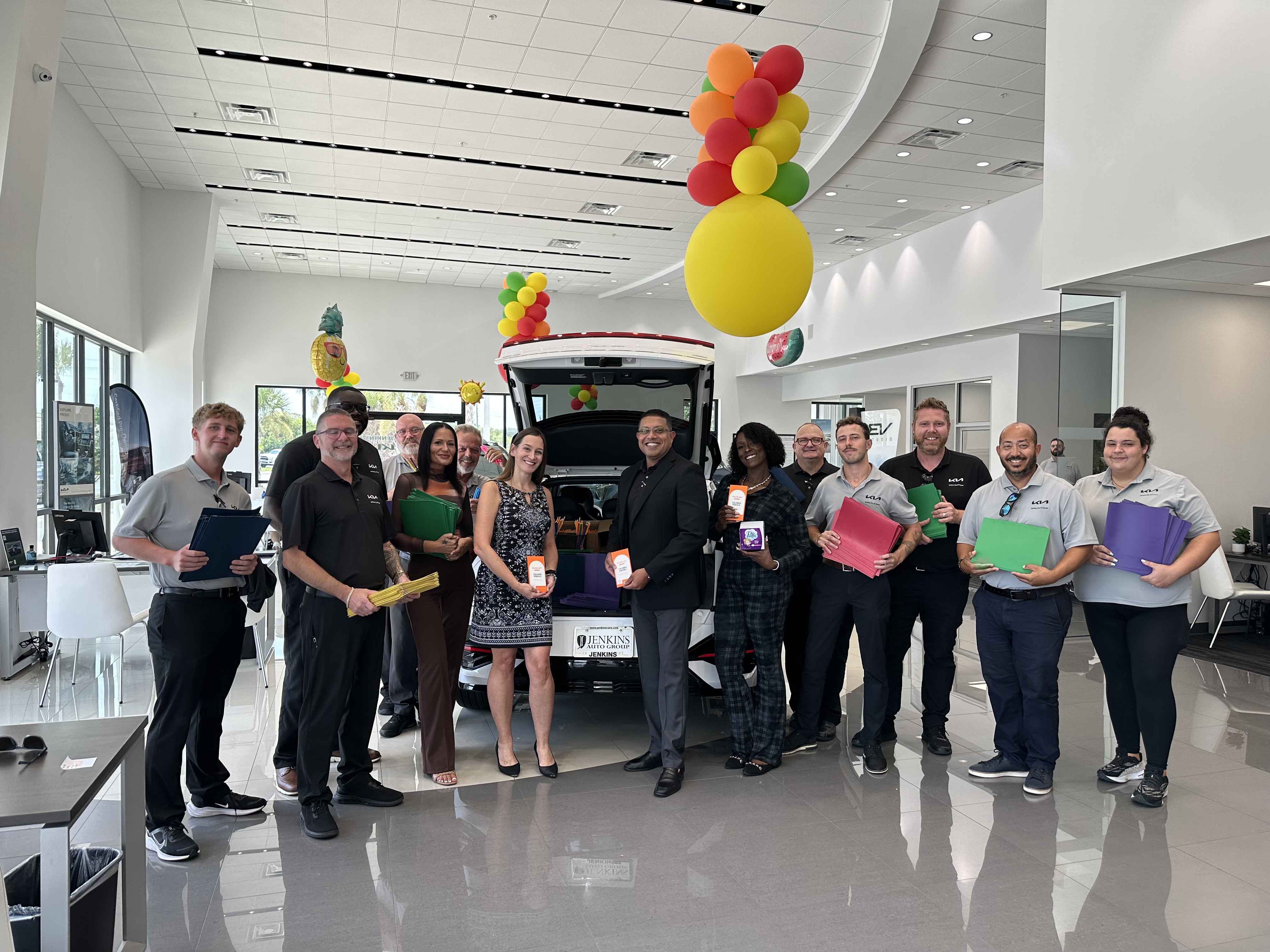 The Jenkins Kia of Cocoa team with donated school supplies in the showroom