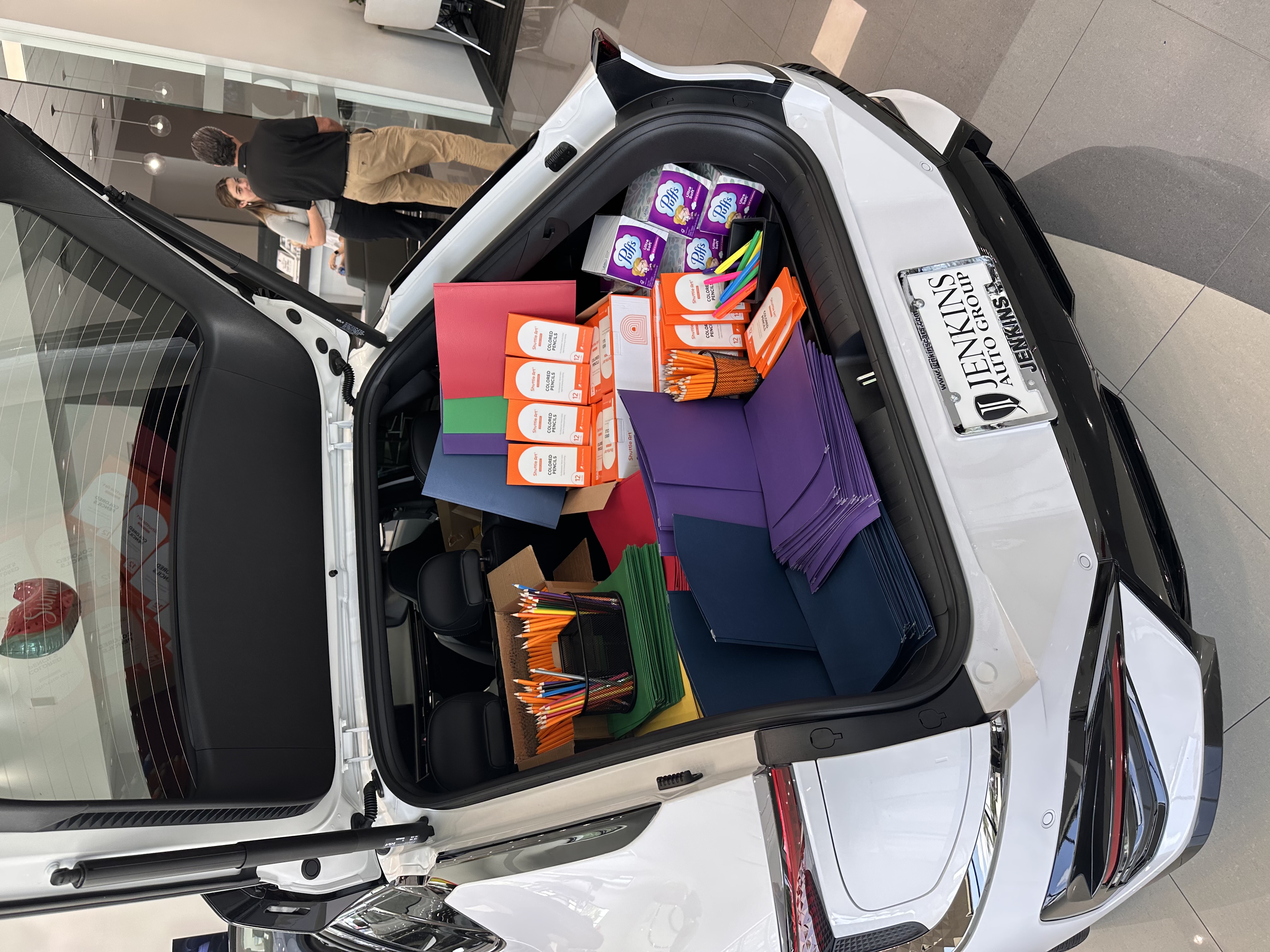 A Kia loaded with folders, pencils, and classroom supplies