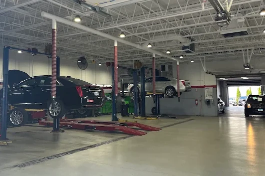 A Cadillac sedan on a lift in the Rizza service department